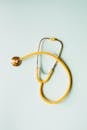 Contact Health Brand Tech Top view of yellow medical stethoscope placed on white surface during coronavirus pandemic